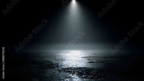 Dramatic spotlight shining on wet asphalt in dark mysterious environment