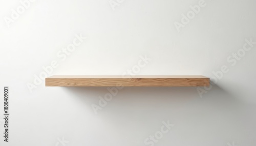 Minimalist floating shelf made of light oak wood. This simple contemporary furniture piece is mounted on a plain white wall. It offers a clean design for modern interiors and home decoration. © Viktor