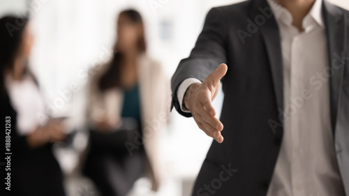 Fotografía Close up confident businessman in formal suit extending his hand forward in welcoming handshake, gesture as beginning or finalizing successful business meeting or negotiation