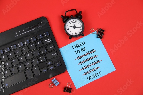Symbol of being yourself. Memo pad with the words 'I NEED TO BE MYSELF', not smarter, thinner, prettier, better. Red background. Psychological concept, being yourself in the workplace environment.