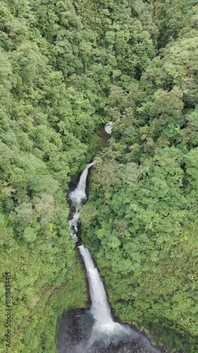 Top down aerial view of tall waterfall in tropical rainforest