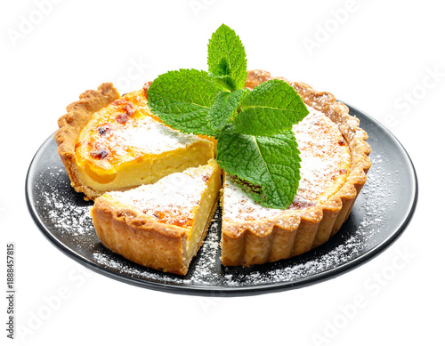 A freshly baked tart with a golden-brown crust, dusted with powdered sugar, and garnished with vibrant mint leaves