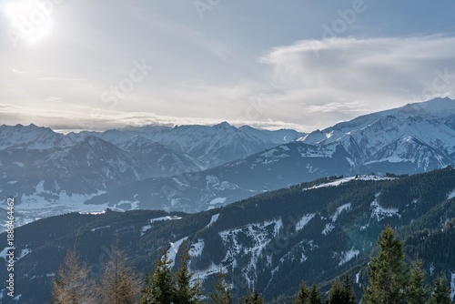 Wallpaper Mural Stunning view of a serene mountain range with snow-capped peaks and lush evergreen forests. Perfect for travel and nature-themed projects, evoking wonder and adventure. Torontodigital.ca