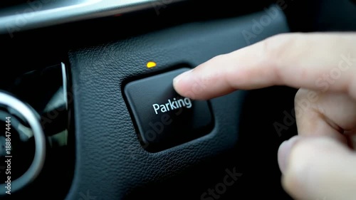 Hand Pressing Parking Assist Button in Car.