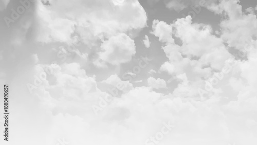 A view from below of large white clouds in the gray sky.