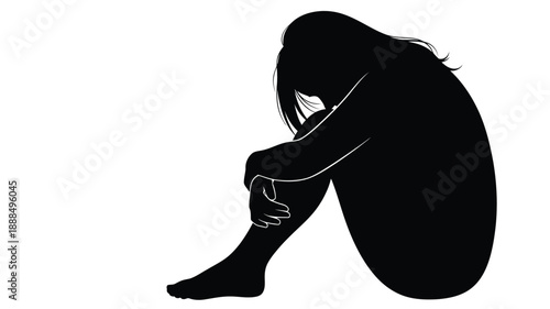 A solitary figure sits with head in hands conveying sadness silhouette