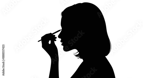 Silhouette portrait of a woman applying makeup with a pencil highlighting her features and style