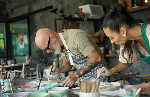 A happy couple makes ceramic plates in a workshop