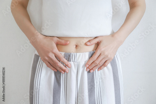 Foto お腹を押さえる女性の腹部　ダイエット