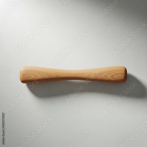 Smooth wooden dumbbell lies upon a textured surface with subtle light play