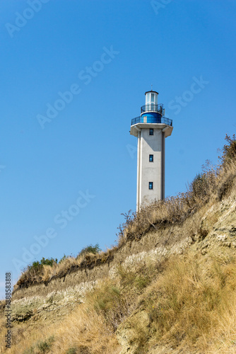 Lighthouse on the hill with blue empty sky