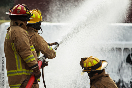 Photos Firefighters spraying water to control fire during emergency training