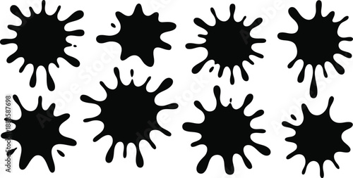 Several dark black ink splatters of various irregular shapes are spread across a white surface