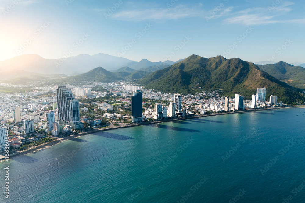 Obraz premium Overlooking aerial panorama view city on the gold main resort coast of Southeast Asia in the hot sunny day Nha Trang the mountains is in the distance