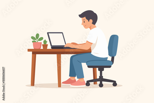 Young man studying or working remotely on laptop at his home office desk