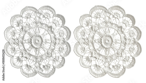 Two identical, circular white lace doilies with intricate floral and geometric patterns on black