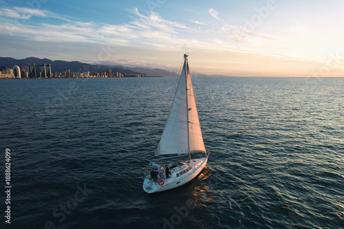Bild auf Leinwand A sailing yacht glides across the calm waters of the Black Sea near Batumi, Georgia, during a warm golden sunset