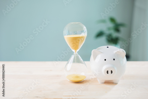 Fototapeta Save money and invest dividend income interest fund in pig piggy bank, hourglass