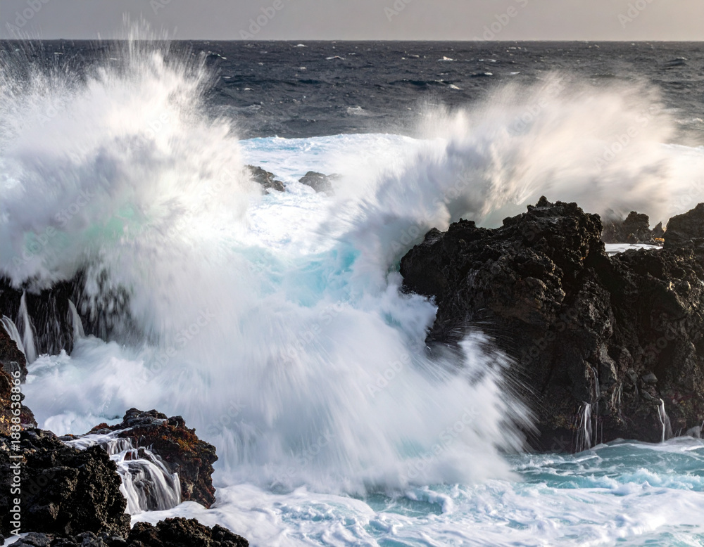 Obraz premium Ocean waves crashing against rocky coastline