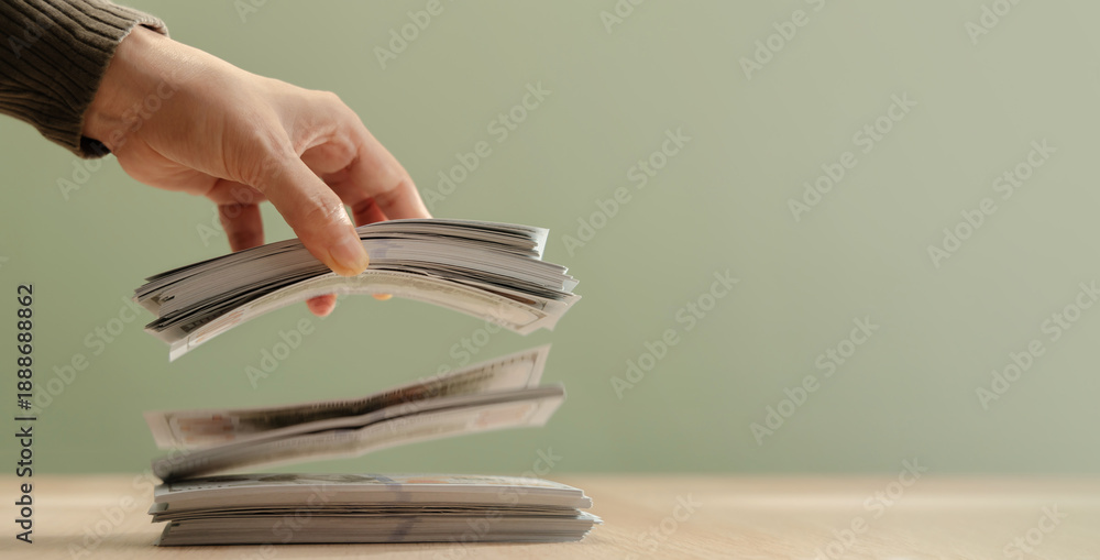 Photography Hand releasing bundles banknotes falling onto stack