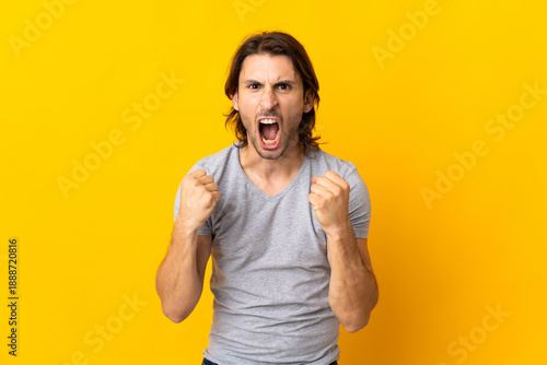 Photos Young handsome man isolated on yellow background frustrated by a bad situation
