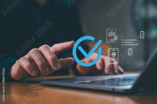 Businessman use computer laptop review electronic files, utilizing intelligent management system to validate records and streamline final approvals, Digital document workflow and quality assurance