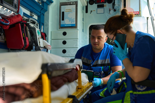 Ambulance staff completing medical paperwork. calling by mobile phone