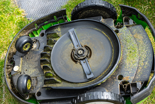 Underside of lawn mower showing blade and wheels.