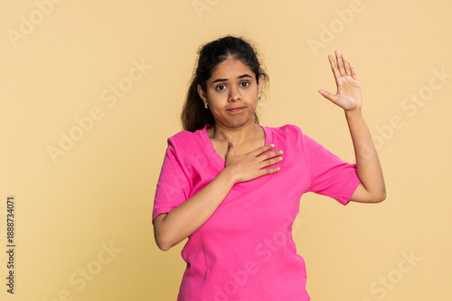 Принти на полотні Indian woman solemnly raises hand and places other hand on heart, clearly performing oath gesture