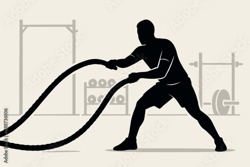 Silhouette of a man exercising with battle ropes in a gym.