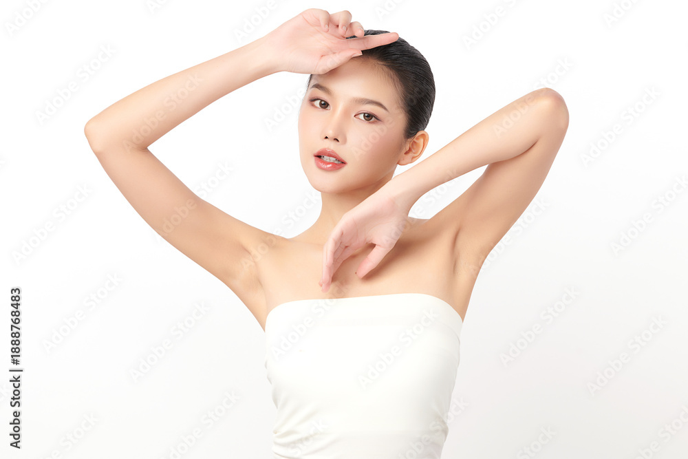 Naklejka premium Beautiful Young Asian woman Raises her hands to Showcase clean and hygienic underarms Against a white background, Smooth armpit cleanliness and protection concept