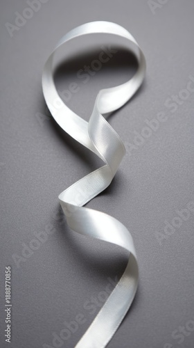 drape. A white ribbon curving downward against a minimalist gray background. wellbeing guides, coaching materials, designed for mental health education and mindfulness programs, clarifies learning.
