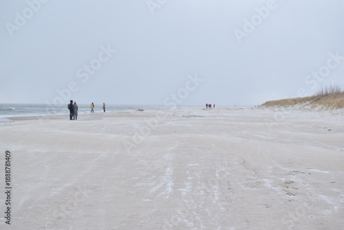 Dramatic stormy sky over an empty sandy beach with waves and dark clouds. Moody seascape landscape with strong wind, cold atmosphere and vast open space. Minimalist coastal scenery, solitude and natur