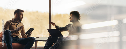 Photos Two men are engaged in conversation in a bright office