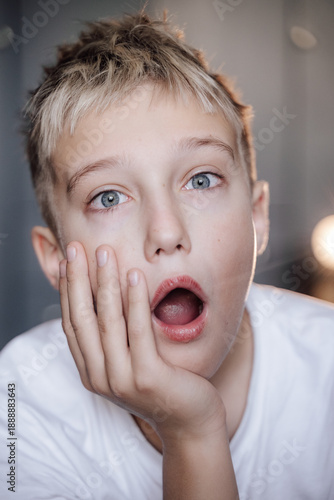 A handsome blond boy with blue eyes expresses emotions
