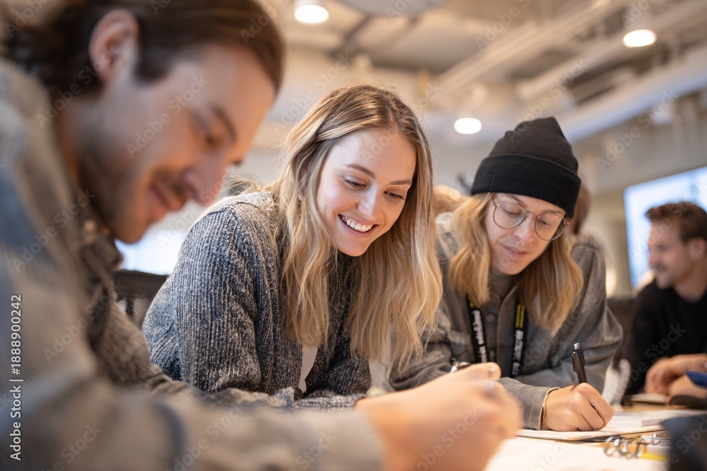 Fototapeta premium Young adults collaborating and brainstorming together in modern office
