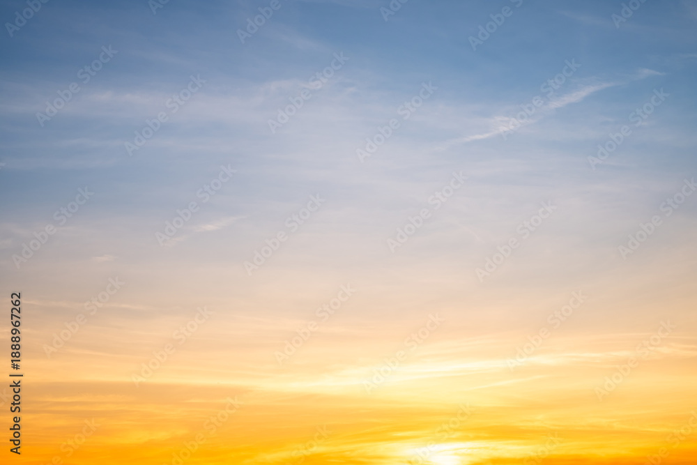 Obraz premium Sunset or sunrise sky with a vibrant gradient of orange, gold, and soft blue. Clear atmosphere with wispy clouds. Peaceful, natural light background. hope, freedom, new day and inspirational Concepts