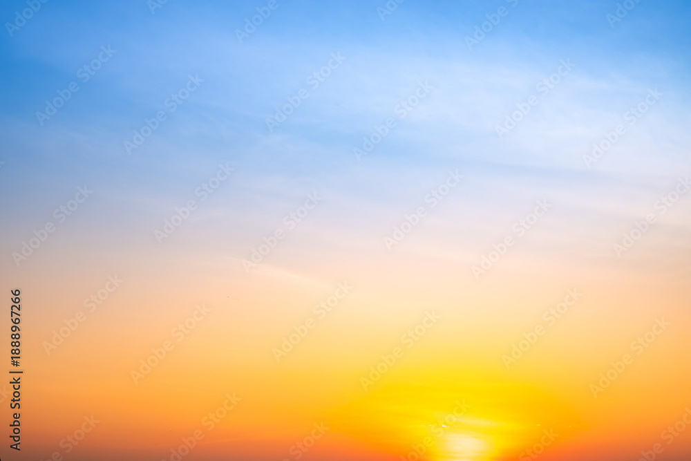 Obraz premium Sunset or sunrise sky with a vibrant gradient of orange, gold, and soft blue. Clear atmosphere with wispy clouds. Peaceful, natural light background. hope, freedom, new day and inspirational Concepts