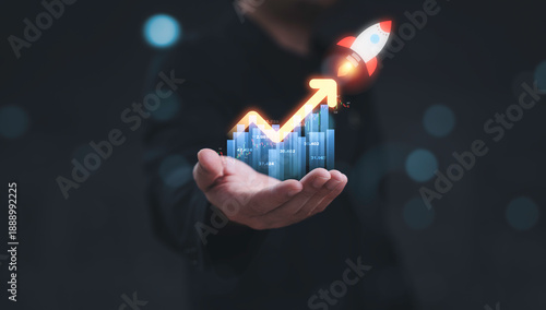 Fotografie Businessman holding financial graph with upward arrow and rocket representing stock market profit dividend success for good trading performance and business investment growth strategy concept