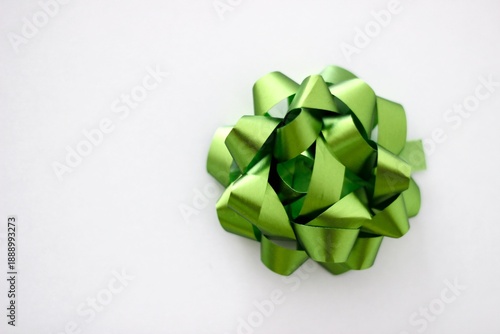 Overhead view of a Single green present bow on a white background