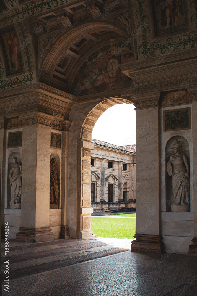 Fototapeta premium Arco aperto su giardino del palazzo. Architettura classica con archi, affreschi e stature a Mantova.