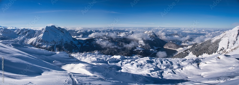 Fototapeta premium Ski tour to the Lachenstock mountain above Lake Wägital. Fantastic skitour in the snow-covered mountains with breathtaking views. Skimo near the Mountain Mutteristock. Swiss Alps. High quality photo