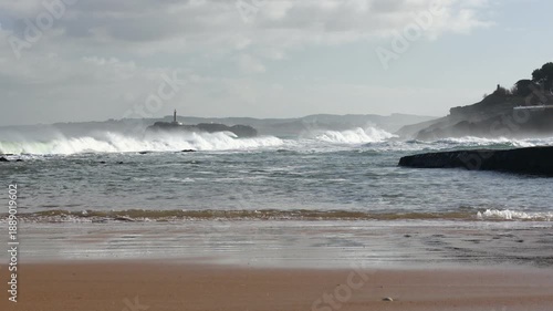 The turbulent ocean is flooding the coastal rocks on the beautiful Sardinero beach in Santander. The Cantabria region in Spain.