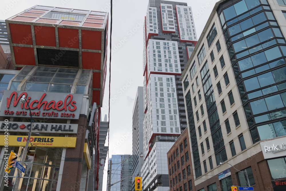 Fototapeta premium Michael's and No Frills signs at Rio Can Hall incl (tall building at right) Picasso Condominiums, looking west on Richmond St W at John St, Toronto
