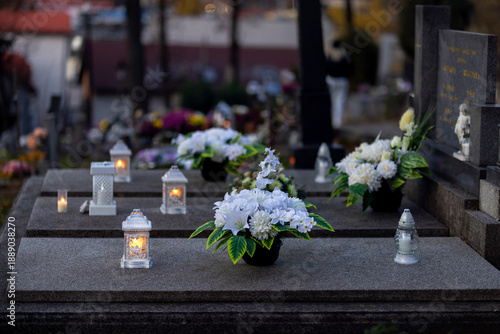 Lit burning candle at night on black stone monument in cemetery. Memory of the deceased. Expression of love