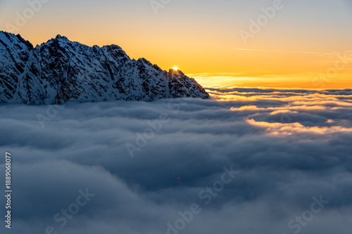 Winter sunset view of High Tatra mountains, with valleys filled by clouds, seen from Szpiglasowy Wierch to the Hruby Peak, Poland, Slovakia