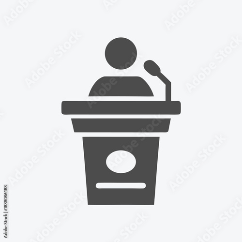 Simple figure stands behind podium and addresses unseen audience during formal speech
