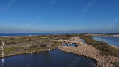 Panoramic landscape of natural lagoons and wetlands with a small white boat on a sunny day