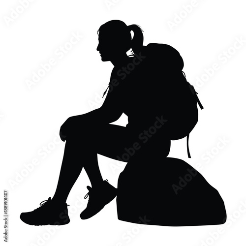 Silhouette of a hiker resting on a rock facing towards the left