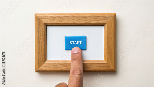 Start button with finger pressing it in wooden frame on white background, symbolizing beginning or initiation of task management up